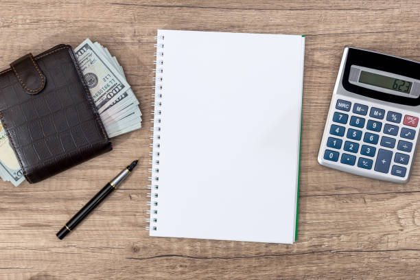 istock notepad with pen, calculator, dollar bills on desk. 672426682