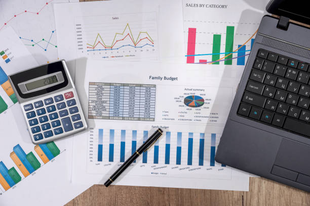 istock analyzing investment charts with laptop on desk. 672433184