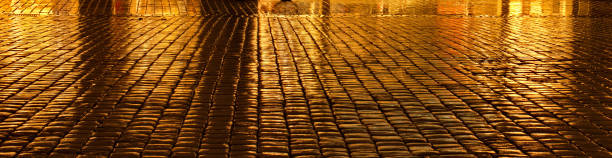 istock golden shimmering cobblestones by rain 672437356