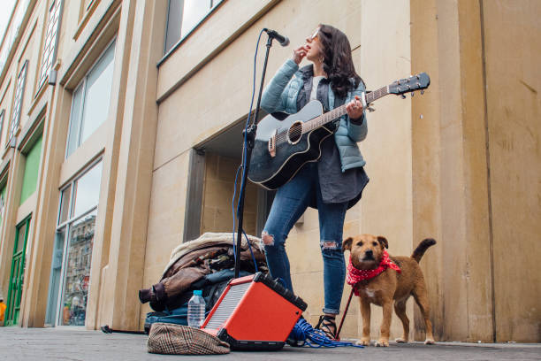 大道芸人と彼女の犬 - street musician ストックフォトと画像