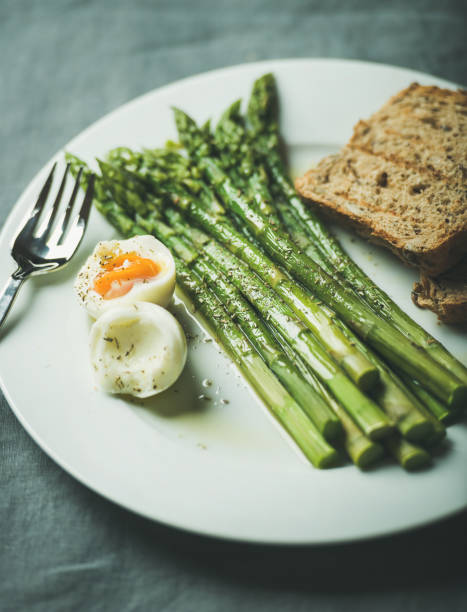 istock Cooked asparagus with soft-boiled egg, grilled bread toasts and herbs 672444280