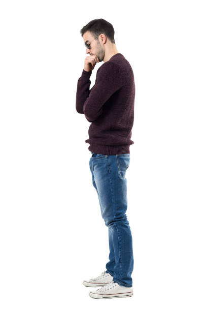 istock Side view of sad worried man in maroon pullover looking down. 672446496