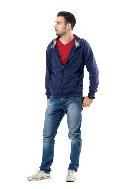 istock Cool smiling young handsome man in sweatshirt with hands in back pockets looking away 672449366