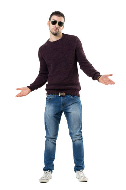 istock Unsure young man wearing sweater and sunglasses shrugging shoulders 672449680