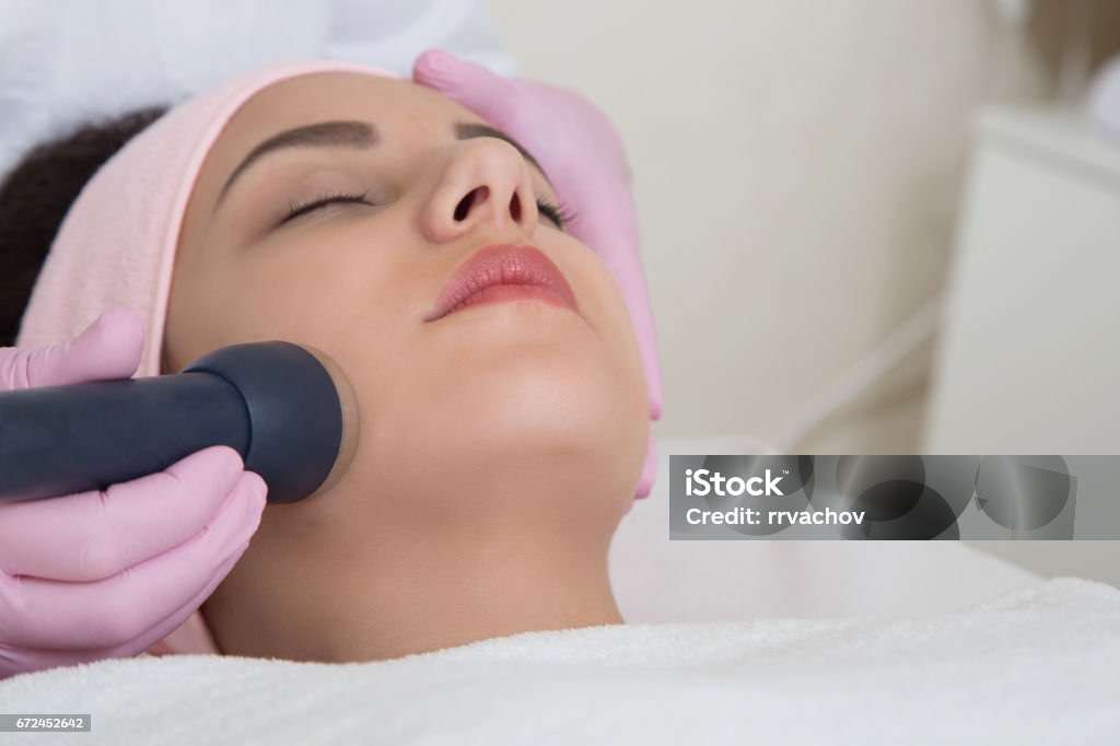 Young woman visiting cosmetologist Young woman visiting cosmetologist today. Tool in hand. Healthcare And Medicine Stock Photo