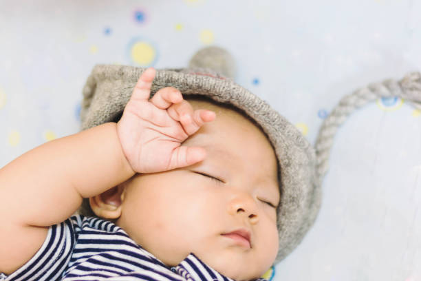 istock Asian baby laying down on ground at park 672453342