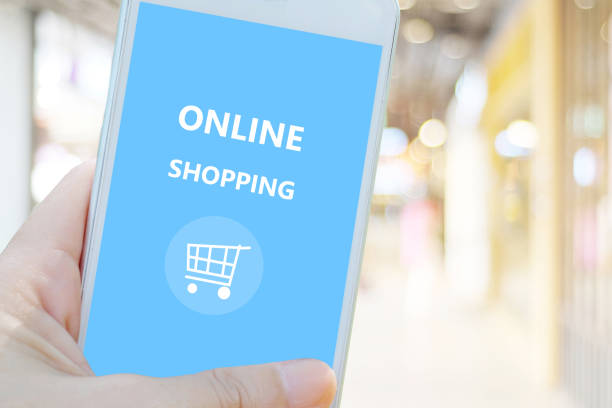 istock Hand holding smart phone with online shopping device on screen over blur store background, business and technology, online shopping, digital marketing concept 672453502