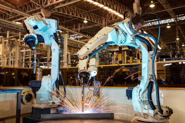 チームのロボットが工場で自動車部品を溶接します。 - 自動溶接トーチ ストックフォトと画像
