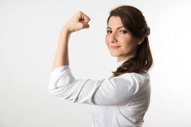 A businesswoman who wears white shirt shows her strong arm