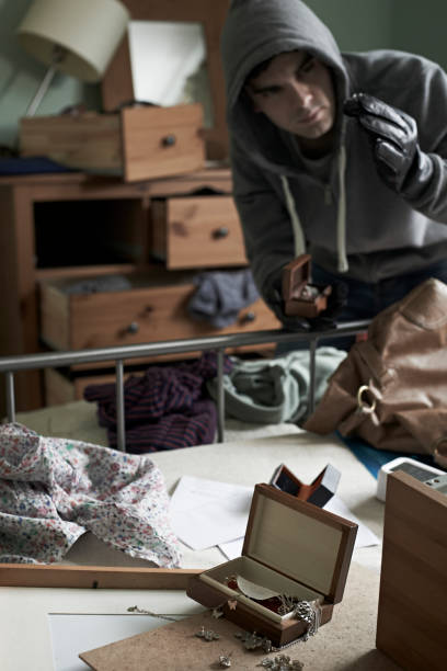 istock Burglar Stealing Items From Bedroom During Hose Break In 672459822