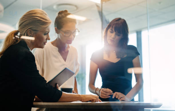 le imprenditrici si disevolano su nuove idee di business - three people group of people standing business person foto e immagini stock