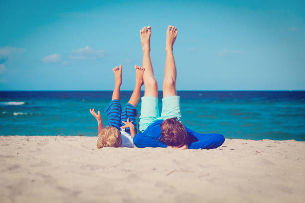 istock father and little son play on beach 672471130