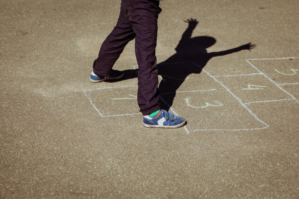 istock little boy playing hopscotch on playground 672474060