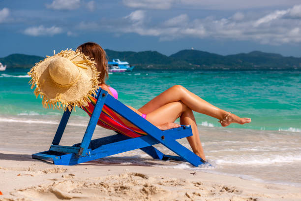 istock Woman in lounger on tropical beach 672475364