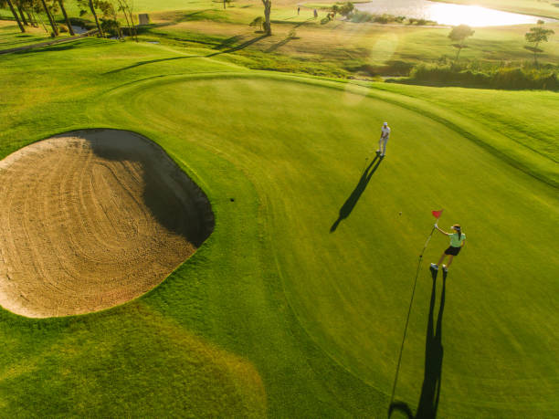 istock Aerial view of golfers on putting green 672477880