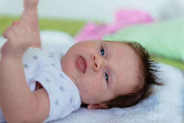 istock Cute blue eye baby with pacifier, lying in bed 672477920