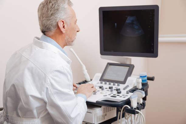 istock Cheerful aging sonographer using professional equipment in the hospital 672478232