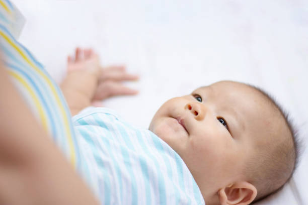 istock cut Asian baby lie on ground 672478314