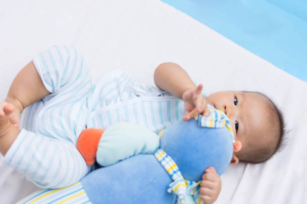 istock cute Asian baby lie on ground playing with toy 672478866