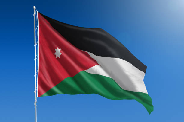 National flag of Jordan on clear blue sky stock photo