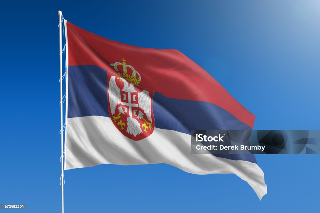 National flag of Serbia on clear blue sky The National flag of Serbia blowing in the wind in front of a clear blue sky Serbia Stock Photo