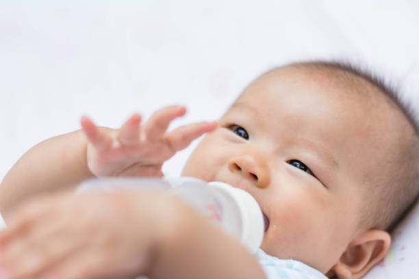 istock Smiling Asian baby infant enjoy drinking water 672482750