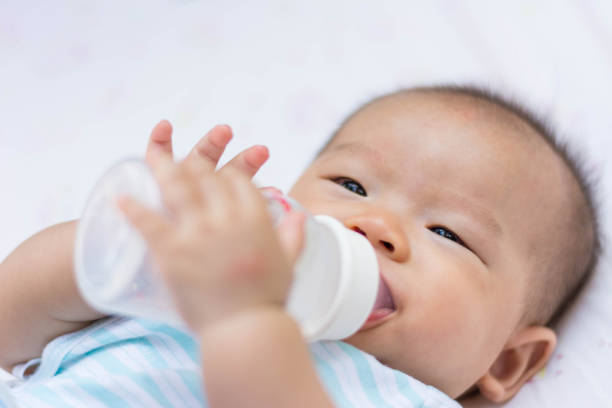 istock Smiling Asian baby infant enjoy drinking water 672483066