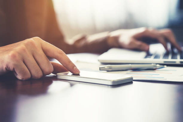 istock Close up business man using smartphone in the office 672483128