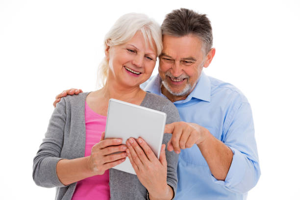 pareja de ancianos que se divierten con la tecnología - standing digital tablet couple love fotografías e imágenes de stock