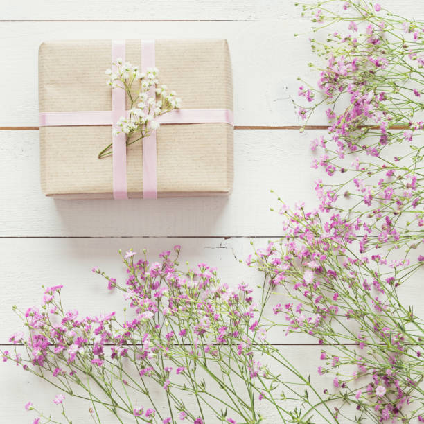 istock Mother's day, white wooden table with flowers and a present 672495818