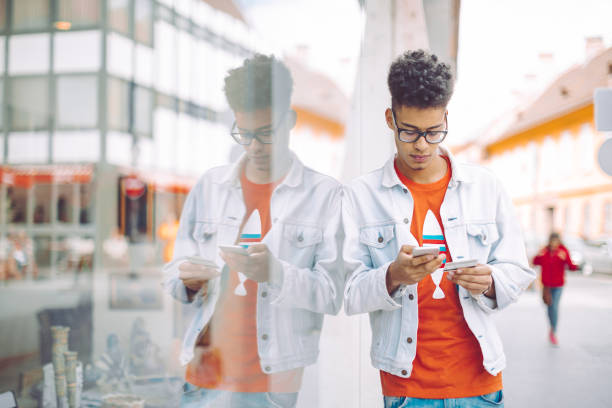 istock Young man using phone in the city 672502520