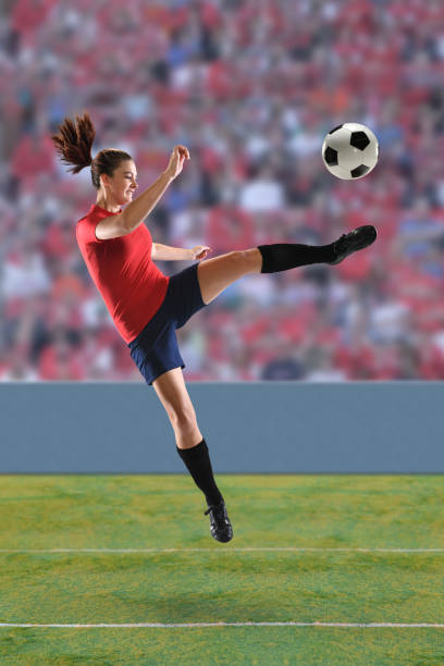 istock Female Soccer Player Kicking Ball 672502622