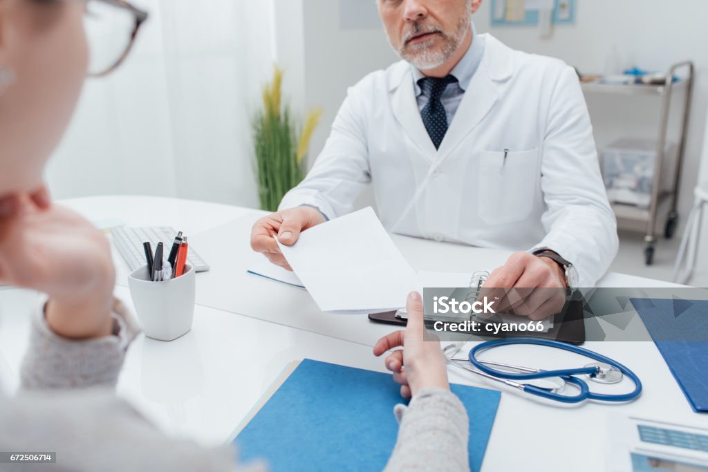 Doctor giving a prescription Doctor giving a prescription to his patient, healthcare and hospitals concept Doctor Stock Photo
