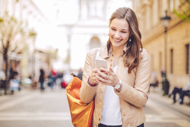 istock Young woman using smart phone in the city 672506782