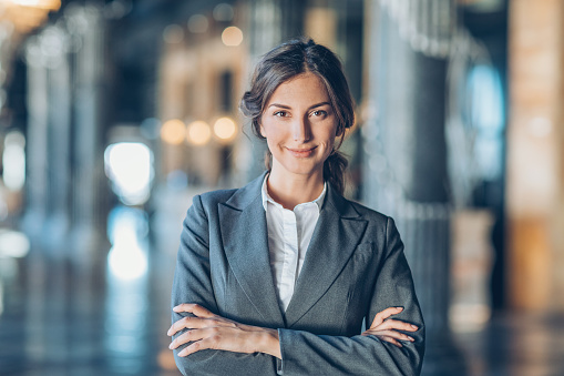 Businesswoman with arms crossed looking at camera, with copy space