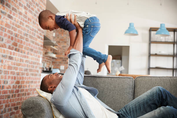 istock Father And Son Having Fun Playing On Sofa Together 672516984