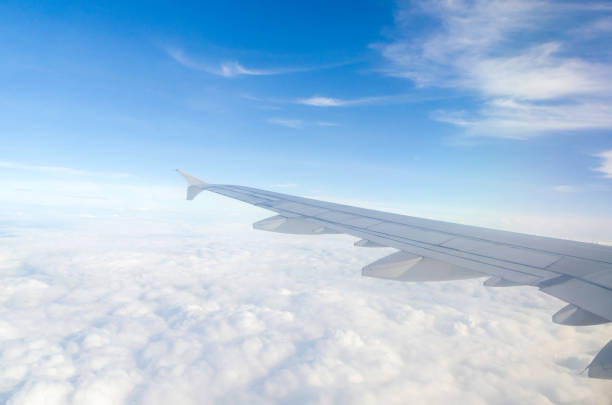 istock Wing of airplane flying above the cloud 672517466