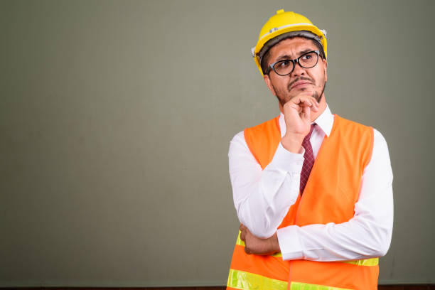 istock Studio shot of mature Persian man construction worker against colored background 672527452