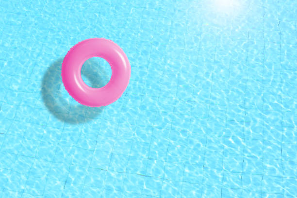 istock pink swimming pool ring float in blue water. concept color summer. 672529612