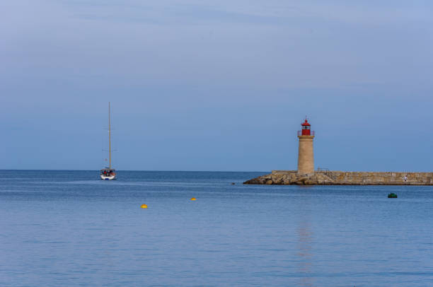 istock Lighthouse and Sailboat - View to ocean 672538070