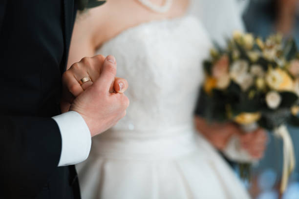 istock Couple holding hands during wedding ceremony 672552420