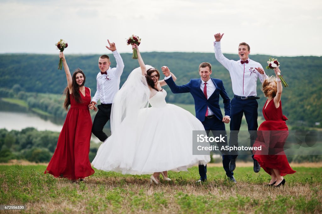 Casal de noivos com as damas de honra e melhor homem caminhar ao ar livre. - Foto de stock de Bouquet royalty-free