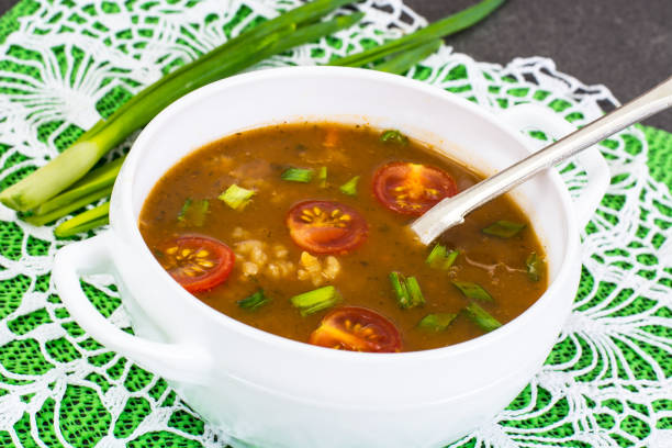 istock Spicy soup with curry, rice and grilled tomatoes 672562480