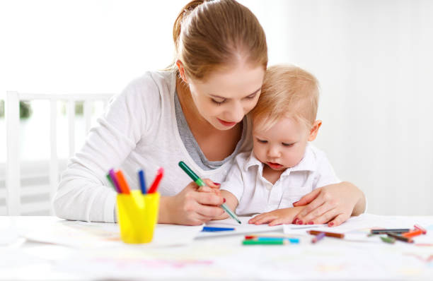 istock Mother with baby son with colored pencils 672582914