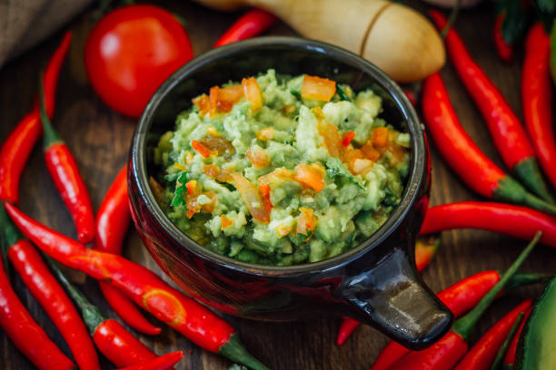 istock Guacamole dip with ingredietns in black ceramic bowl. 672586734