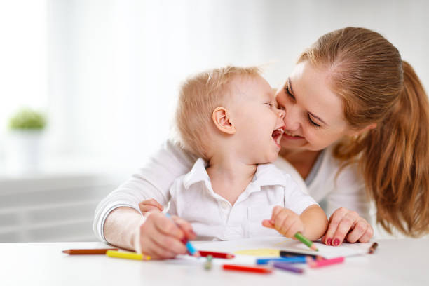 mère avec bébé fils avec des crayons de couleur - mother baby child playing photos et images de collection