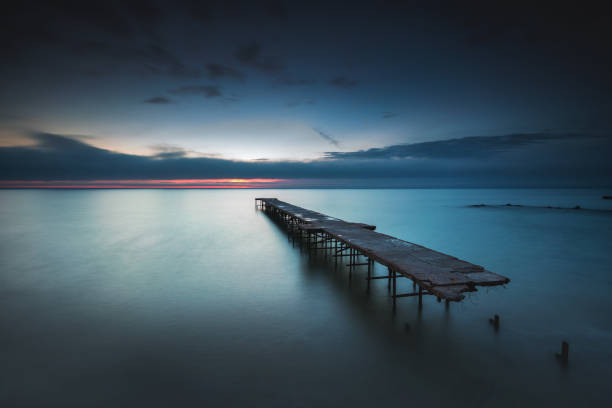 istock Sunrise over Old broken bridge in the sea, long exposure shot 672589826