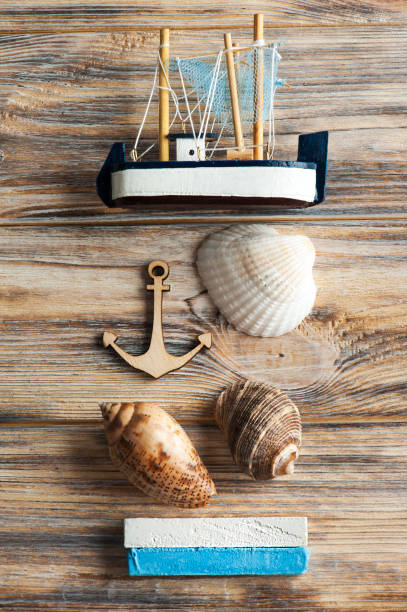 istock Seashells, wooden anchor and toy boat 672590638