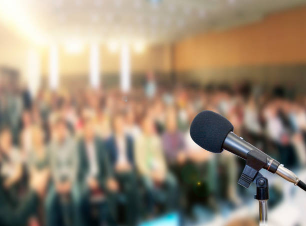 istock Microphone on stage against a background of auditorium 672594274