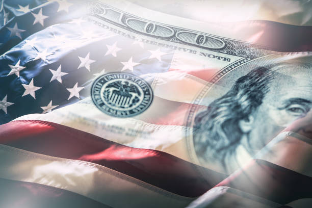 USA flag and American dollars. American flag blowing in the  wind and 100 dollars banknotes in the background stock photo